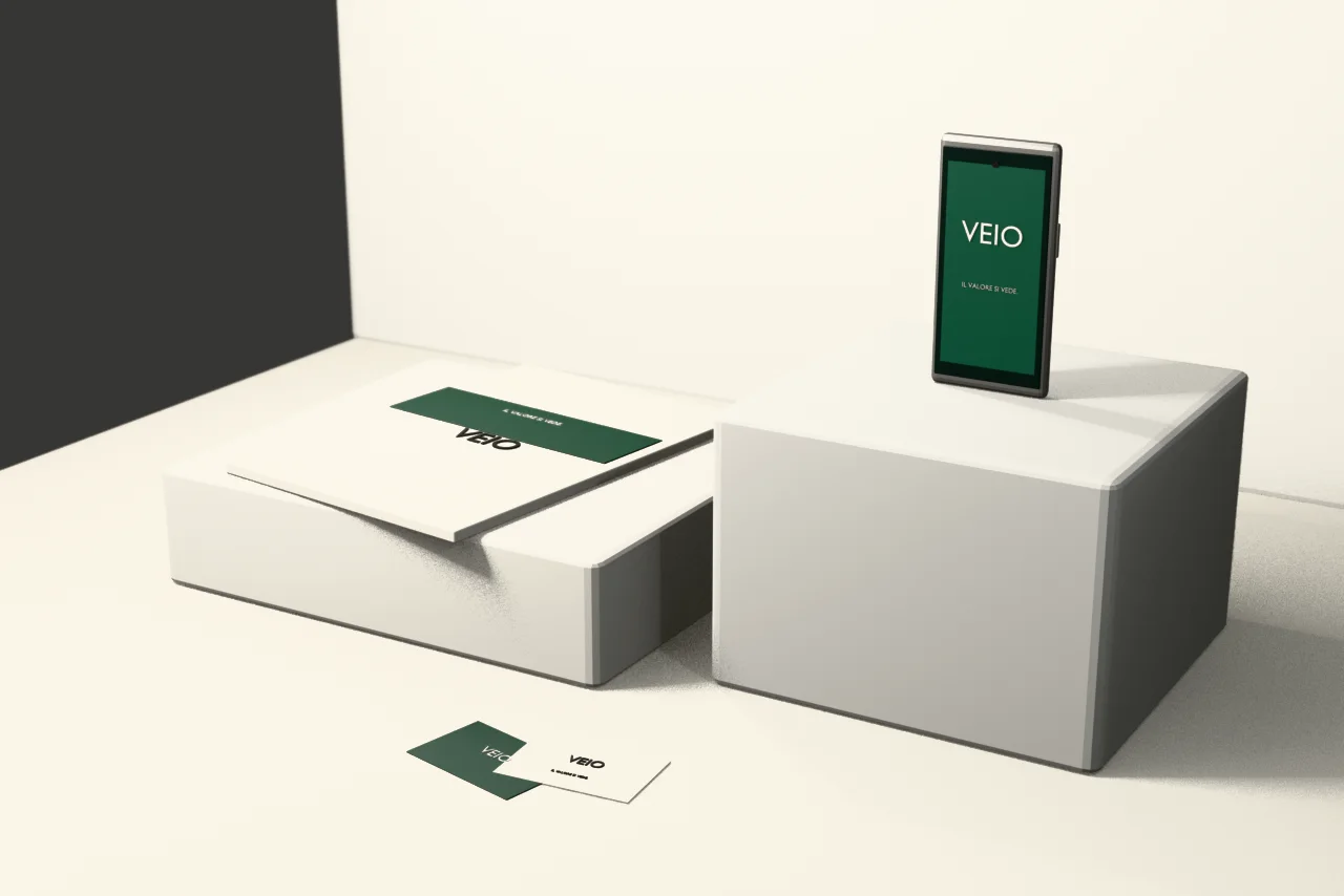 Render concettuale dell’identità VEIO applicata a telefono, booklet e biglietti su podi bianchi